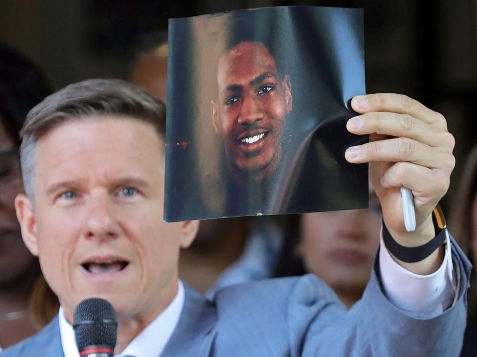 Attorney Bobby DiCello holds up a photograph of Jayland Walker, the man who was shot dead by Akron Police on June 25, as he speaks on behalf of the Walker family during a press conference at St. Ashworth Temple in Akron, Ohio,