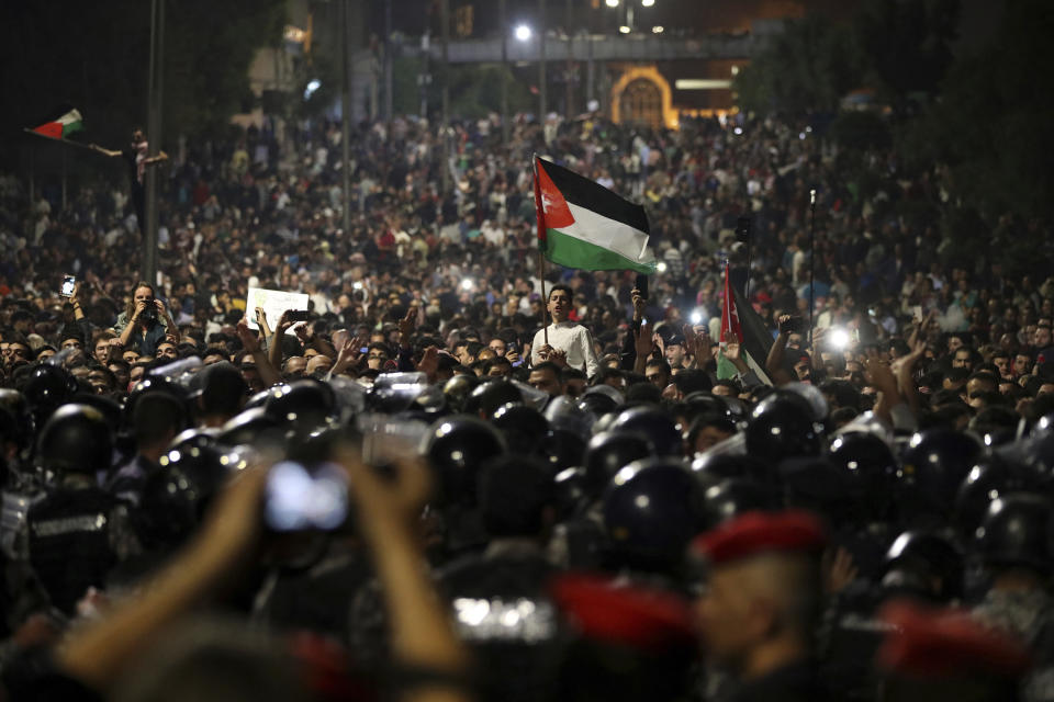 <p>Jordanian protesters shout slogans and raise a national flag during a demonstration outside the Prime Minister’s office in the capital Amman early Monday, June 4, 2018. (Photo: Raad al-Adayleh/AP) </p>