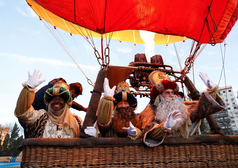 Los Reyes Magos saludan mientras celebran la víspera de la Epifanía antes de sobrevolar la ciudad en un globo aerostático ya que las restricciones de la enfermedad del coronavirus (COVID-19) impiden el tradicional desfile en Sevilla