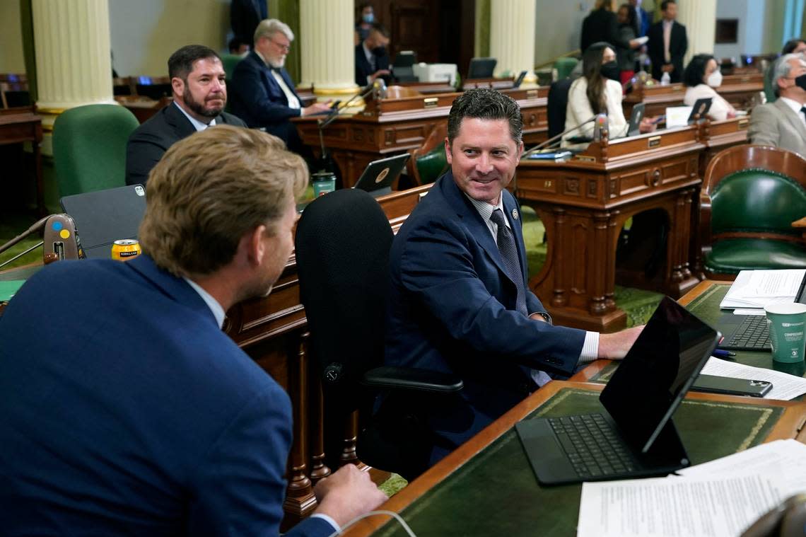 Assemblyman Jordon Cunningham, R-San Luis Obispo, right, smiles after his bill to hold social media companies responsible for harming children who have become addicted to their products was approved by the Assembly at the Capitol in Sacramento, Calif., on Monday, May 23, 2022. At left is Assemblyman Chad Mayes, I-Yucca Valley.