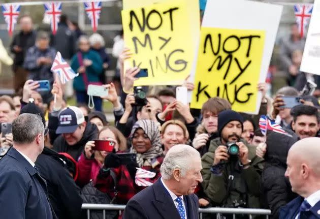 Demonstrators hold placards reading 