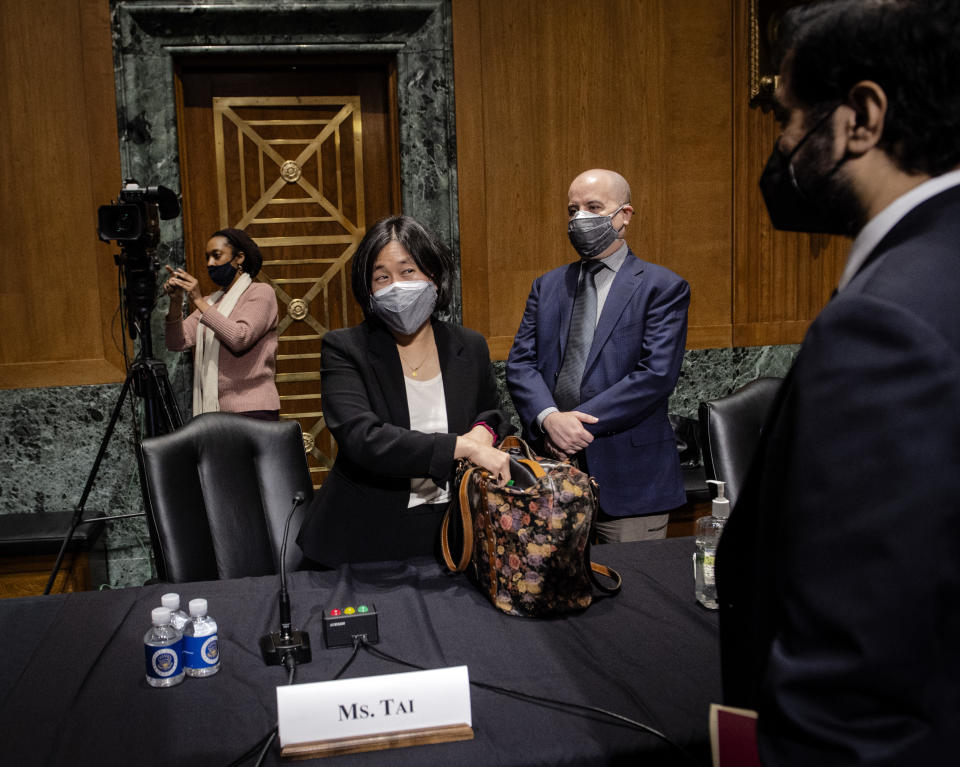 Katherine Tai, nominee for U.S. trade representative, packs up while her husband Robert Skidmore stands behind her after a Senate Finance Committee hearing on Capitol Hill, in Washington, Thursday, Feb. 25, 2021. (Bill O'Leary/The Washington Post via AP, Pool)