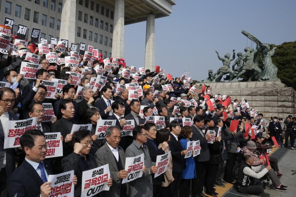 South Korean opposition lawmakers and civic groups stage a rally against the South Korean government's plan over the issue of compensation for forced labors at the National Assembly in Seoul, South Korea, Tuesday, March 7, 2023. South Korean President Yoon Suk Yeol on Tuesday defended his government's contentious plan to use local funds to compensate Koreans enslaved by Japanese companies before the end of World War II, saying it's crucial for Seoul to build future-oriented ties with its former colonial overlord. The signs read "Out with Yoon Suk Yeol's Humiliating Diplomacy." (AP Photo/Ahn Young-joon)