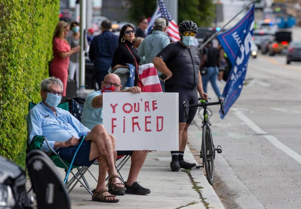 A counter demonstrator awaits the arrival of U.S. President Donald Trump and his motorcade along Southern Boulevard on his way to Mar-a Lago in Palm Beach on Wednesday, Jan. 20, 2021.