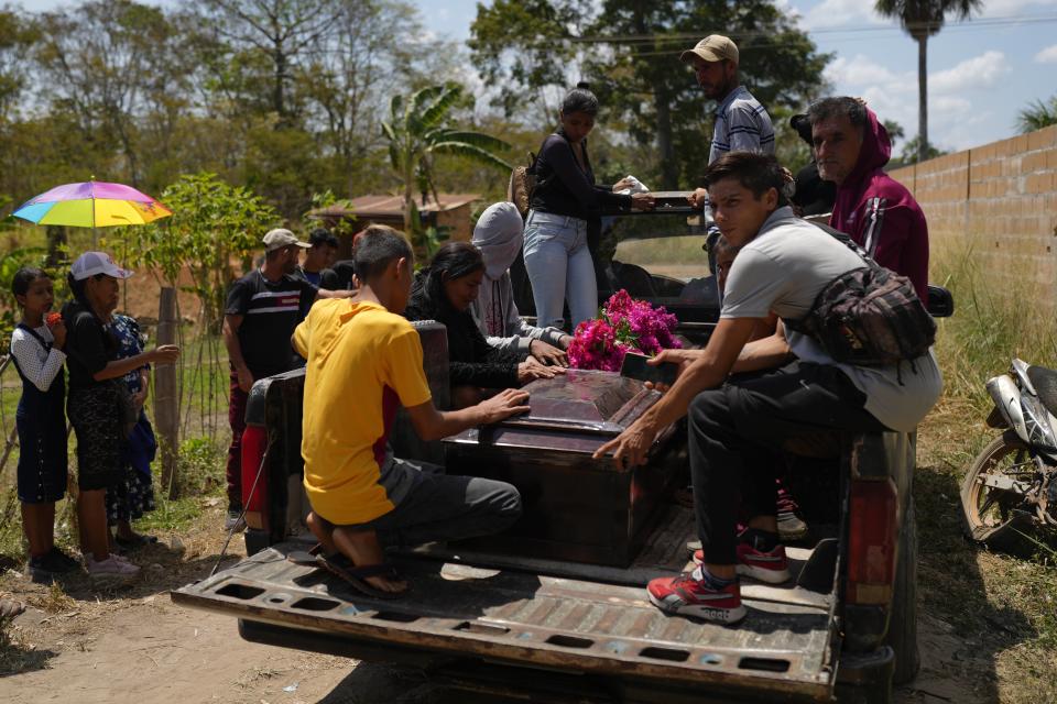 El ataúd con los restos del minero Gerson Leal en una camioneta camino al cementerio en La Paragua, estado de Bolívar, Venezuela, el jueves 22 de febrero de 2024. El colapso de una mina a cielo abierto que operaba ilegalmente en el centro de Venezuela dejó más de una quincena de muertos, incluido a Leal, y varios heridos, informaron las autoridades el miércoles 21 de febrero, que también indicaron que podría haber un número indeterminado de personas atrapadas bajo la tierra. (AP Foto/Ariana Cubillos)