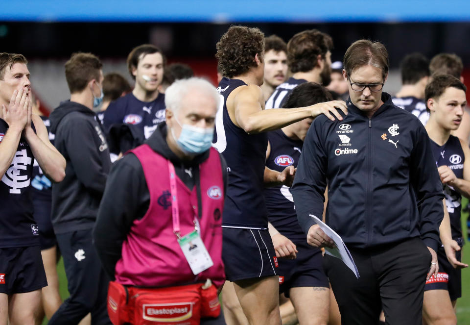 David Teague, Senior Coach of the Blues, is consoled by Charlie Curnow at three quarter time during the 2021 AFL Round 23 match.