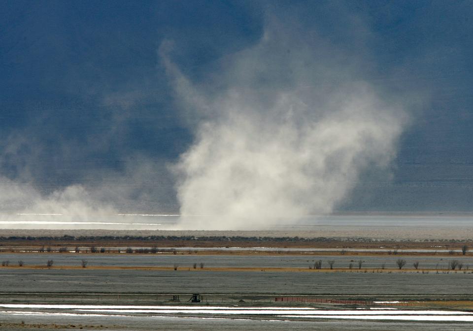 A large dust cloud moves across the dry lake-bed at Owens Lake.