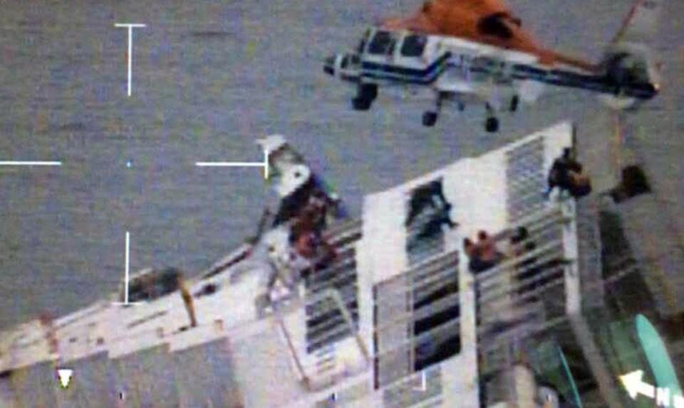 Still image shows a South Korean maritime police helicopter rescuing passengers from a sinking ship in the sea off Jindo