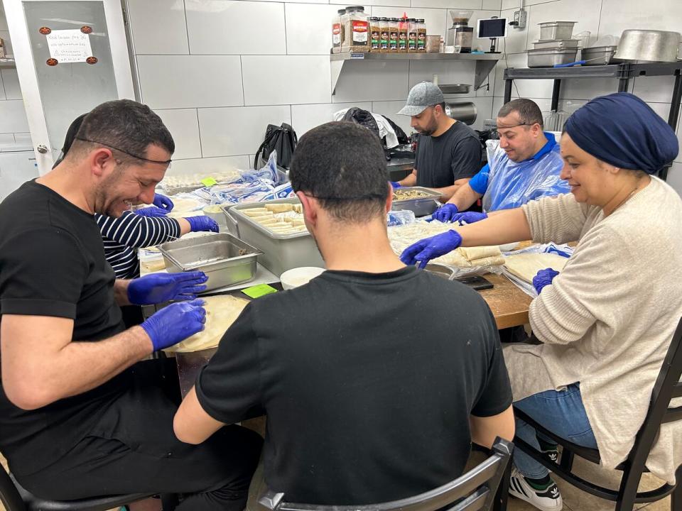 A group of volunteers prepares hundred of boureks, wraps filled with ground meat, cheese and parsley.