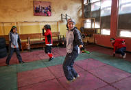 In this Wednesday, March, 5, 2014 photo, an Afghan female boxer, center, jumps rope during a practice session at the Kabul Stadium boxing club. The sportswomen share a camaraderie, laughing and teasing each other until the serious business of training begins. (AP Photo/Massoud Hossaini)