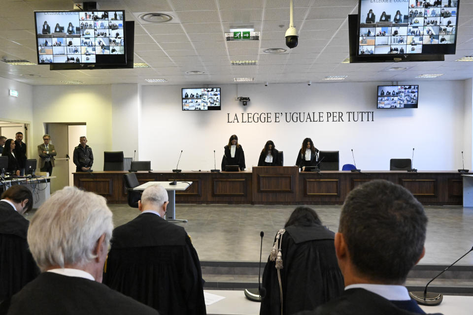 Officials listen as the president of the court judge Brigida Cavasino, center, flanked by judges Claudia Caputo, left, and Germana Radice, reads the verdicts of a maxi-trial of hundreds of people accused of membership in Italy's 'ndrangheta organized crime syndicate, one of the world's most powerful, extensive and wealthy drug-trafficking groups, in Lamezia Terme, southern Italy, Monday, Nov. 20, 2023. Verdicts are expected Monday for the trial that started almost three years ago in the southern Calabria region, where the mob organization was originally based. (AP Photo/Valeria Ferraro)