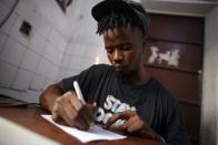 Yousef Kamara works on a poem in the Way Out media center's "Writers Room" in Freetown,