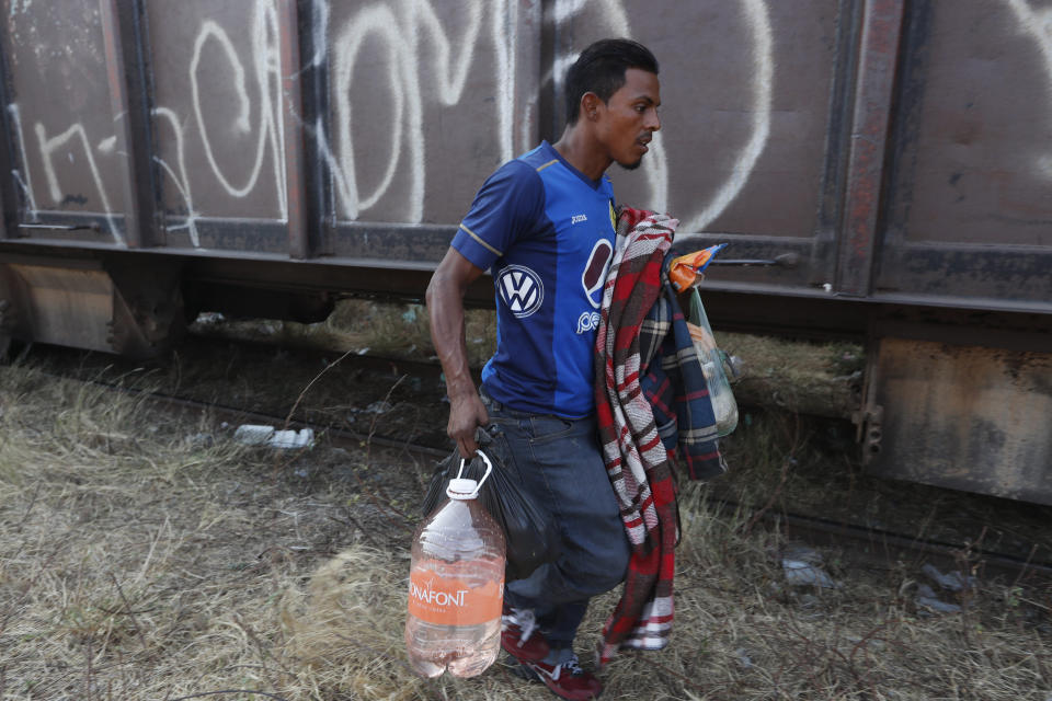 A Central American migrant runs to climb on a passing freight train on his way to the U.S.-Mexico border, in Ixtepec, Oaxaca state, Mexico, Tuesday, April 23, 2019. With throngs of police pickups and small immigration vans parked at checkpoints up and down the narrow waist of southern Mexico, for the migrants hitchhiking, taking buses or walking is no longer an option. (AP Photo/Moises Castillo)