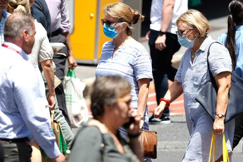 Pedestrians wear face masks in Brisbane.