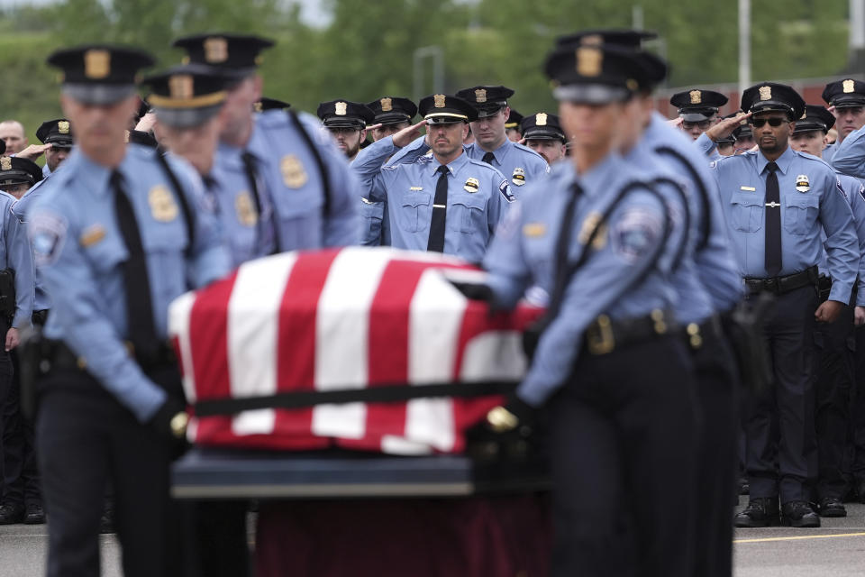 Members of the Minneapolis Police Department salute as an honor guard moves the casket of Minneapolis police Officer Jamal Mitchell into Maple Grove Senior High School for his public memorial service, Tuesday, June 11, 2024, in Maple Grove, Minn. Mitchell was shot and killed while responding to a shooting on May 30, 2024. (AP Photo/Abbie Parr, Pool)