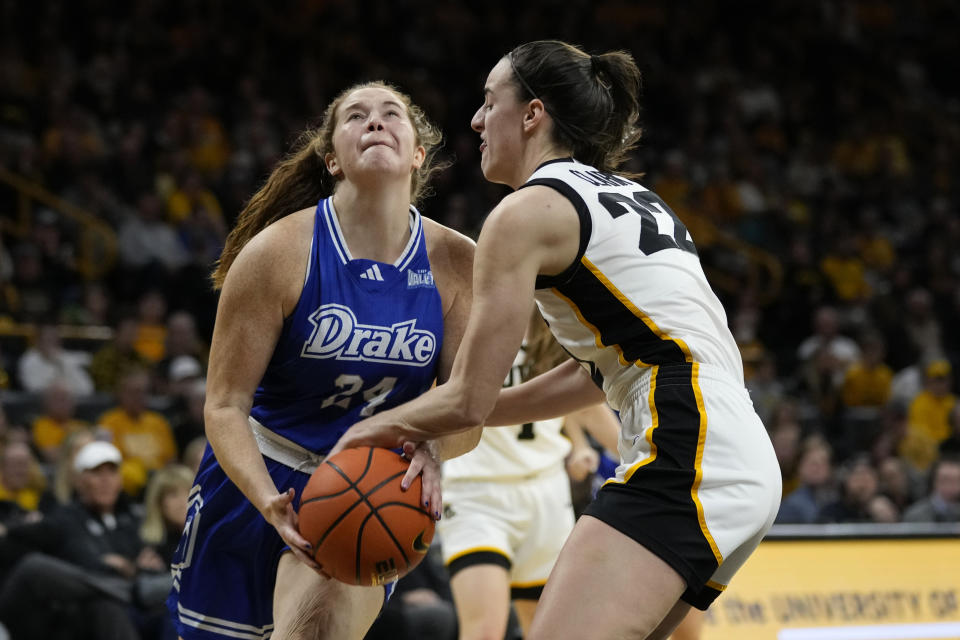 Iowa guard Caitlin Clark (22) steals the ball from Drake guard Anna Brown (24) during the first half of an NCAA college basketball game, Sunday, Nov. 19, 2023, in Iowa City, Iowa. (AP Photo/Charlie Neibergall)