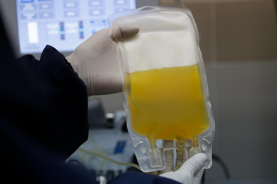 In this June 12, 2020 file photo, a doctor holds a bag of blood plasma donated by a COVID-19 survivor at at blood bank in La Paz, Bolivia.