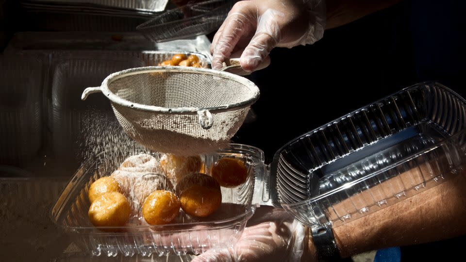 Powdered sugar is sifted on honey puffs to make l'geimats. - James Nielsen/Houston Chronicle/Getty Images