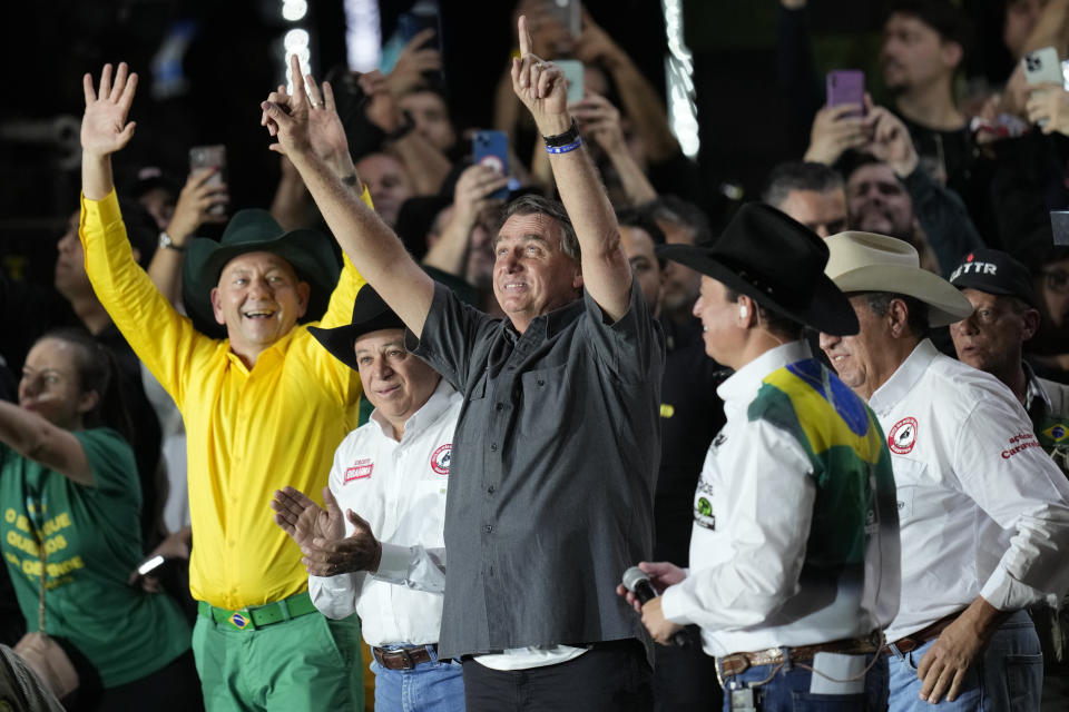 Brazilian President Jair Bolsonaro, center, who is running for a second term, greets supporters at the the Barretos Rodeo International Festival in Barretos, Sao Paulo state Brazil, Friday, Aug. 26, 2022. Brazil's general elections are scheduled for Oct. 2, 2022. (AP Photo/Andre Penner)