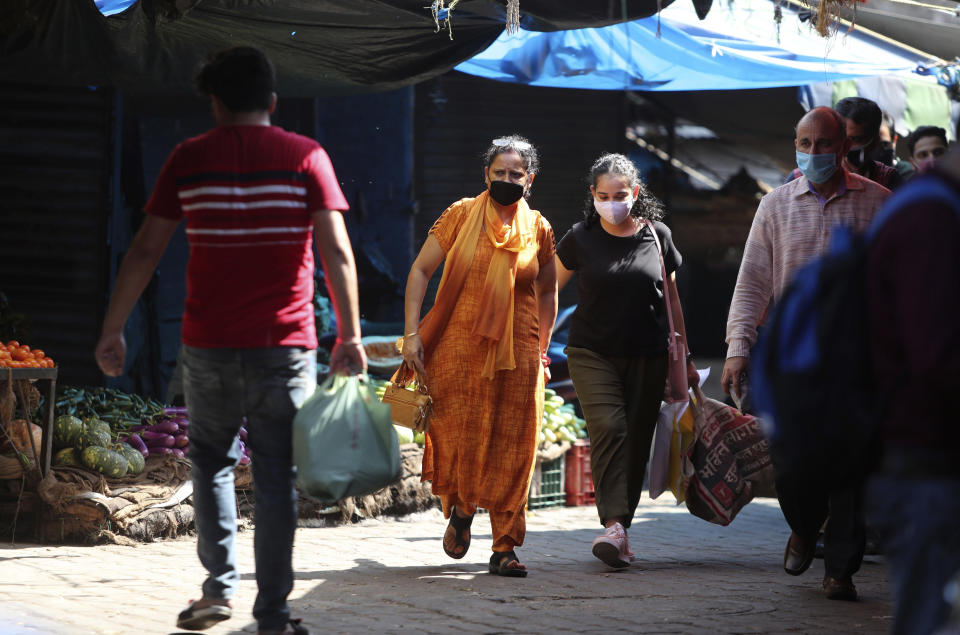 Indians wearing a face masks as a precaution against the coronavirus walk at a vegetables market in Jammu, India, Wednesday, Sept.23, 2020. The nation of 1.3 billion people is expected to become the pandemic's worst-hit country within weeks, surpassing the United States. (AP Photo/Channi Anand)