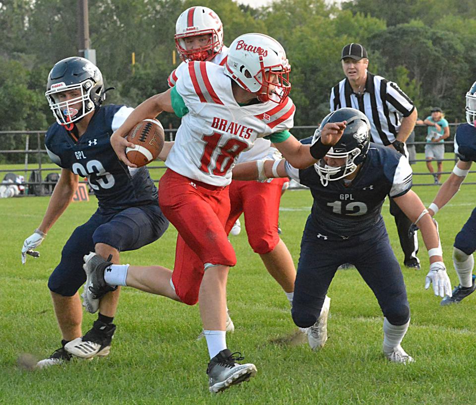 Britton-Hecla quarterback Jaxon Zuehlke tries to get past Great Plains Lutheran defenders Lucas Johnson (23) and Thomas Erickson (12) during their season-opening high school football game on Friday, Aug. 18, 2023 at Watertown Stadium.