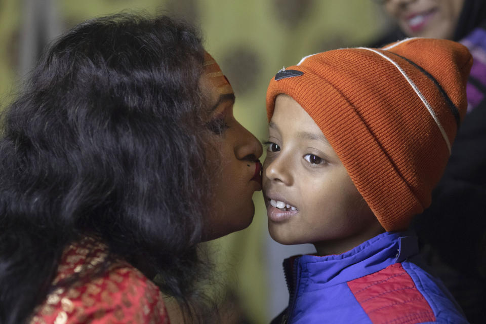 In this Jan. 13, 2019 photo, Laxmi Narayan Tripathi, an Indian transgender activist and leader of the "Kinnar akhara" monastic order, gives a kiss to a Hindu boy during a reception to followers at the Kumbh Mela festival in Allahabad, India. This is the first time Tripathi’s newly formed Akhara has set up camp at the massive temporary city in Prayagraj. The Kinnars’ tent camp on the edge of the festival grounds is adorned with Ardhanari, the androgynous composite image of the Hindu god Shiva and his consort Parvati, that religious scholars date to the 1st century. (AP Photo/Bernat Armangue)