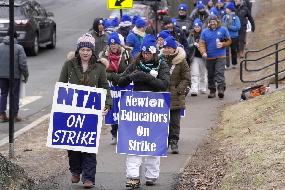 Striking Newton teachers and supporters carry placards while marching, Tuesday, Jan. 30, 2024, outside the Newton Education Center, in Newton, Mass. Contract negotiations between the Newton Teachers Association and the city's School Committee continued Tuesday. (AP Photo/Steven Senne)