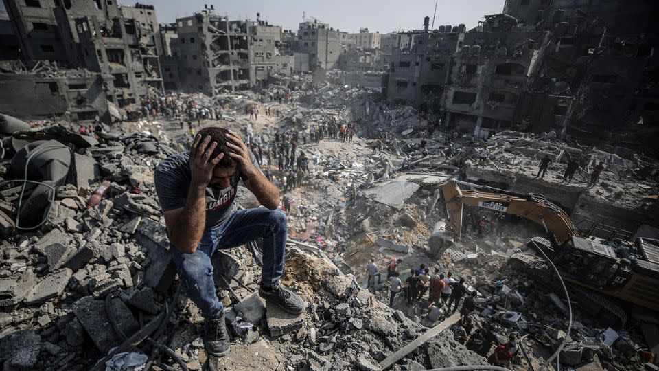A man, sitting on debris, reacts as Palestinians conduct a search and rescue operation after a second bombardment of the Israeli army at Jabalia refugee camp in Gaza on November 1, 2023. - Ali Jadallah/Anadolu/Getty Images