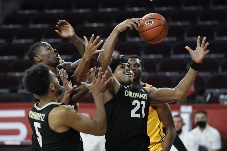 Colorado's Evan Battey, center, grabs a rebound during the second half of the team's NCAA college basketball game against Southern California, Thursday, Dec. 31, 2020, in Los Angeles. Colorado won 72-62. (AP Photo/Jae C. Hong)