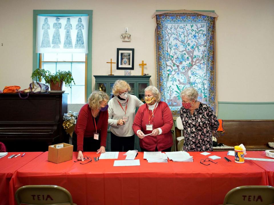 PHOTO: Peaks Island residents Lois Tiedeken, Kathy McCarthy, Stephanie Castle and Judy Nelson, left to right, talk about intake paperwork prior to the start of an immunization clinic at Brackett Memorial Methodist Church on Peaks Island, Feb. 14, 2021. (Portland Press Herald via Getty Images)