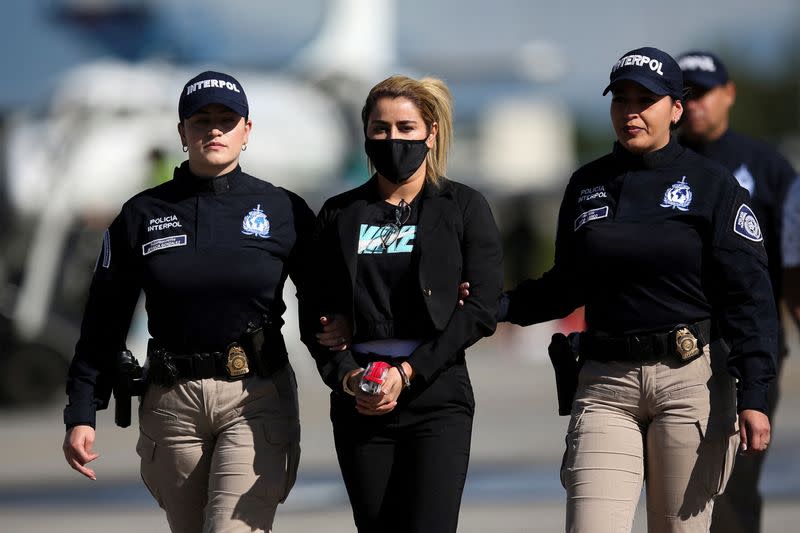 Colombian National Police officers escort Nini Johana Usuga, alias 'La Negra', at the Military Transport Air Command (CATAM) in Bogota