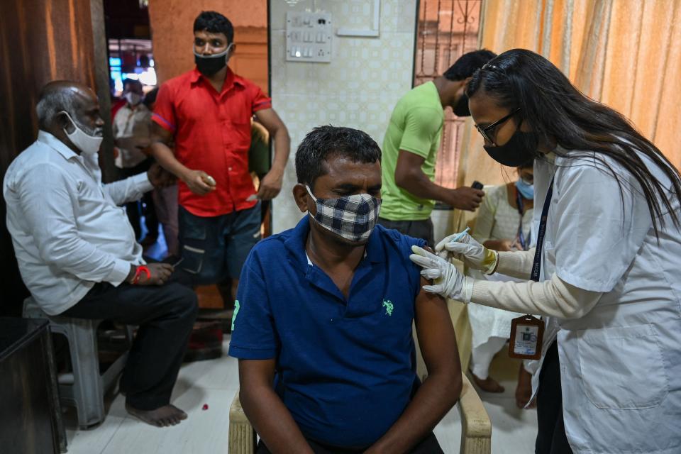 A worker gets inoculated against Covid-19 at a temporary vaccination centre in Mumbai on 19 October 2021 (AFP via Getty Images)