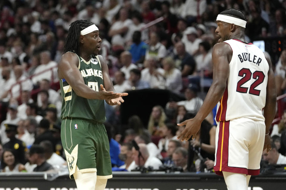 Milwaukee Bucks guard Jrue Holiday, left, talks to Miami Heat forward Jimmy Butler (22) during the second half of Game 3 in a first-round NBA basketball playoff series, Saturday, April 22, 2023, in Miami. (AP Photo/Lynne Sladky)