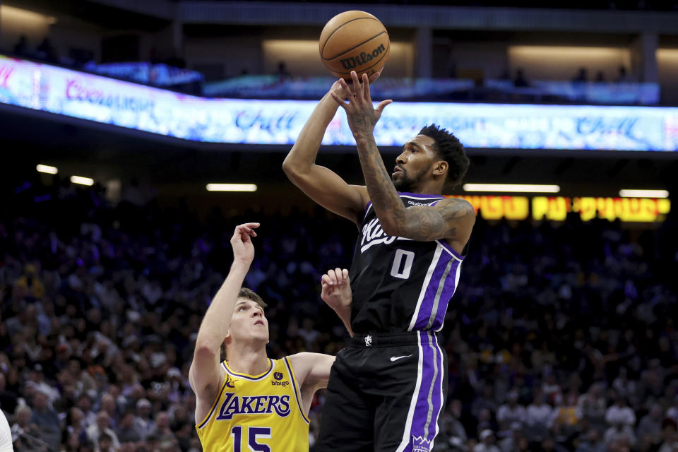Sacramento Kings guard Malik Monk (0) shoots against Los Angeles Lakers guard Austin Reaves (15) during the second half of an NBA basketball game in Sacramento, Calif, Wednesday, March 13, 2024. (AP Photo/Jed Jacobsohn)