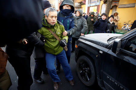 A supporter of prominent rights lawyer Wang Quanzhang is detained outside the courthouse where Wang's trial is held, in Tianjin, China December 26, 2018. REUTERS/Thomas Peter