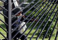 A member of the riot security forces points a gun from behind the fence of an air force base during clashes with opposition supporters at a rally against Venezuelan President Nicolas Maduro's government in Caracas, Venezuela June 22, 2017. REUTERS/Carlos Garcia Rawlins