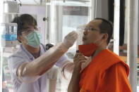 Health workers collect a nasal swab sample from a Buddhist monk to test for the coronavirus at the Wat Pho temple in Bangkok, Thailand, Saturday, May 30, 2020. (AP Photo/Sarayuth Jojaiharn))