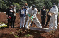 People attend the burial of a relative who died from complications related to COVID-19 at the Vila Formosa cemetery in Sao Paulo, Brazil, Wednesday, April 7, 2021. (AP Photo/Andre Penner)