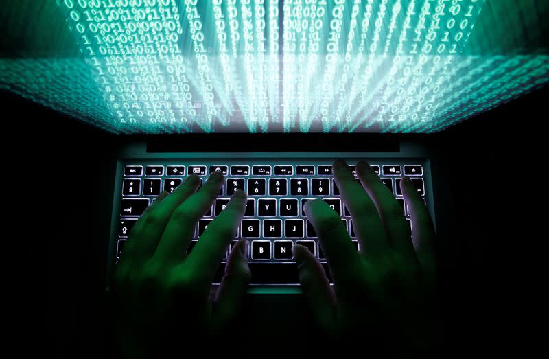 FILE PHOTO: Illustration file picture shows a man typing on a computer keyboard in Warsaw