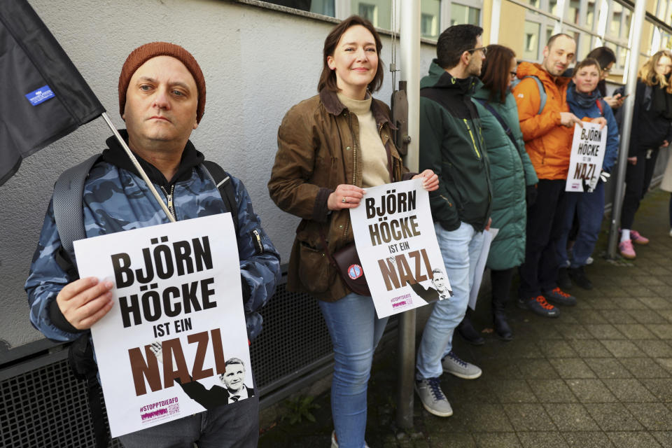 Protestors hold banners reading 'Bjoern Hoecke is a nazi' outside the state court in Halle, Germany, Thursday, April 18, 2024. Bjoern Hoecke, goes on trial at the state court in Halle on charges related to his alleged use in a 2021 speech of a slogan used by the Nazis' SA stormtroopers. (Fabrizio Bensch/Pool via AP)