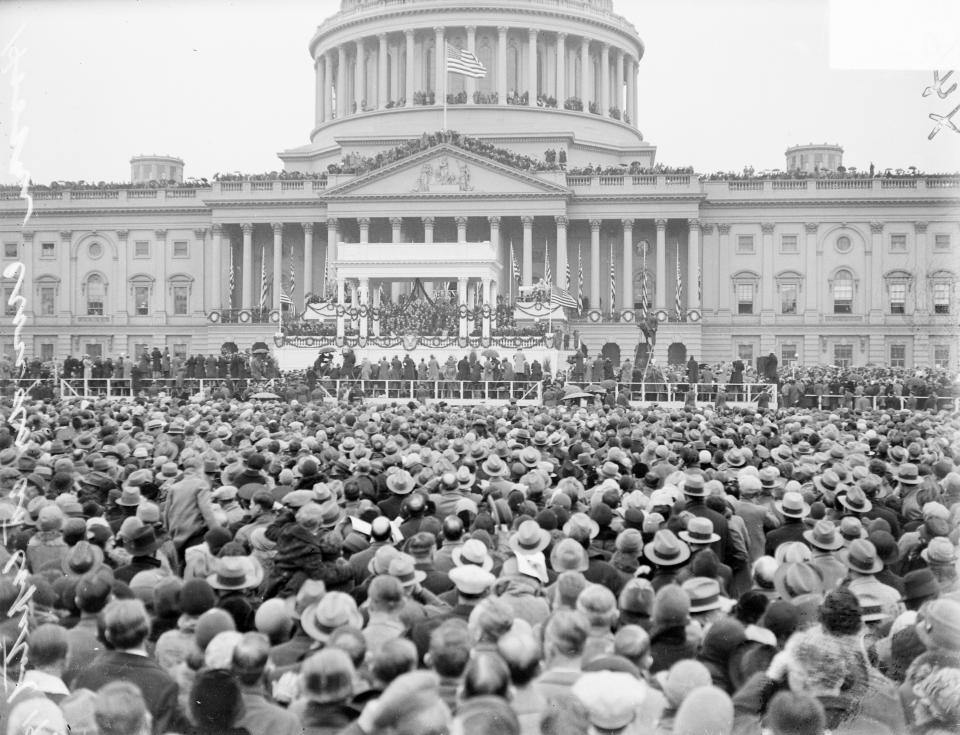 Crowds stand in front of a decoration platform in front of the Capitol during the inauguration of Herbert Hoover on March 4, 1929.