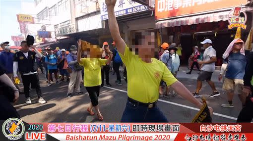 當鑾轎進入了沙鹿鬧區後，竟衝出某宮廟一男一女，身穿黃衣、手拿黑令旗意圖「攔轎」。（圖／翻攝自白沙屯拱天宮YouTube）