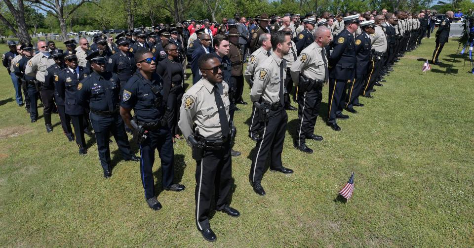 Law enforcement officers gather at the graveside during the funeral for Montgomery County Sheriff's Deputy Jermyius Young in Montgomery on April 15. Young died from injuries he sustained in a crash while responding to a call.