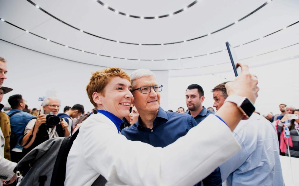 Apple CEO Tim Cook poses for a selfie with journalist Britta Weddeling during a launch event in California in 2018 - AFP/NOAH BERGER 