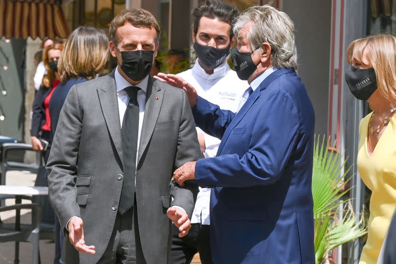 French President Emmanuel Macron talks with restaurant owner Michel Chabran as he arrives for a lunch in Valence