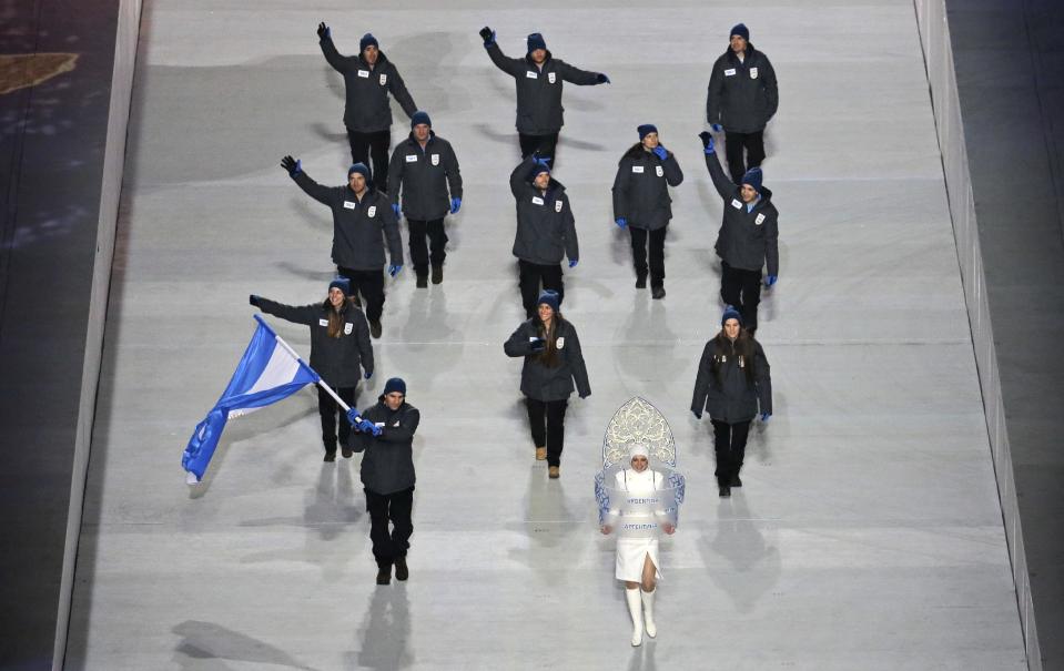 Cristian Simari Birkner of Argentina holds his country's national flag and enters the arena with his team during the opening ceremony of the 2014 Winter Olympics in Sochi, Russia, Friday, Feb. 7, 2014. (AP Photo/Charlie Riedel)