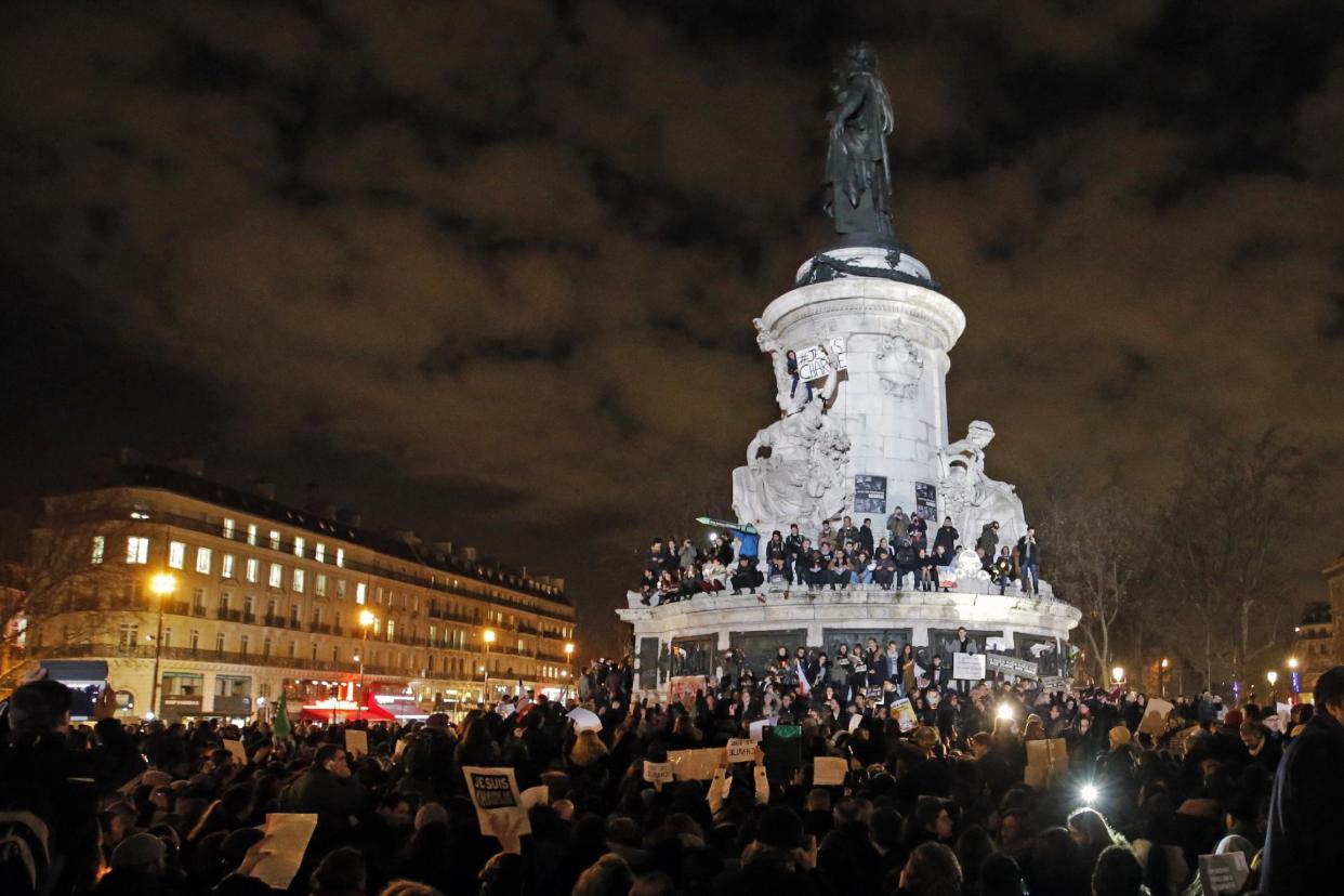 CLICK IMAGE for slideshow - People gather around and on top of the Republique Plaza statue during the solidarity demonstration in Paris, Thursday, Jan. 8, 2015. (AP Photo/Francois Mori)