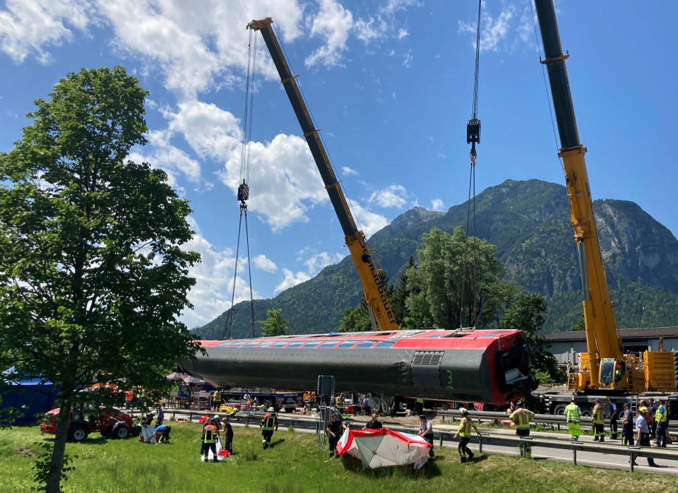 A carriage is being lifted on the site of a train crash in Burgrain, near Garmisch-Partenkirchen, Germany, Saturday, June 4, 2022. Authorities say a train accident in the Alps in southern Germany on Friday left at least four people dead and many more injured. Police said the regional train headed for Munich appears to have derailed shortly after noon in Burgrain — just outside the resort town of Garmisch-Partenkirchen, from where it had set off. Three of the double-deck carriages overturned at least partly, and people were pulled out of the windows to safety. (Sabine Dobel/dpa via AP)