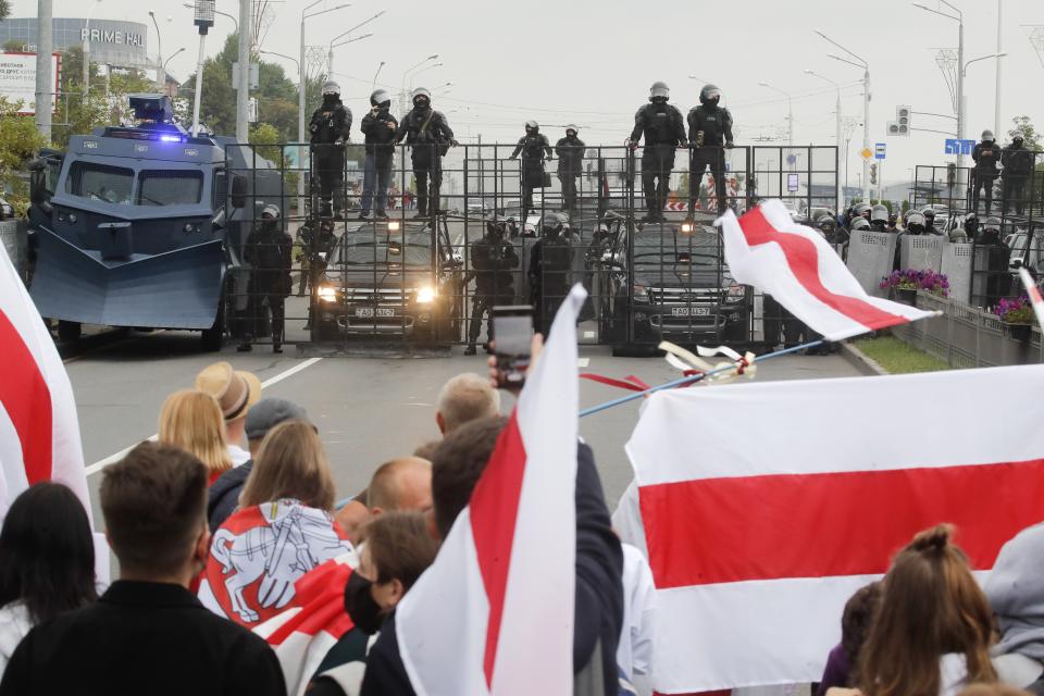 FILE - In this Aug. 23, 2020, file photo, demonstrators face a roadblock manned by riot police during a protest in Minsk, Belarus. With protests in Belarus now in their third week — including rallies that brought out an estimated 200,000 people in Minsk for the last two Sundays — President Alexander Lukashenko is moving to squelch the demonstrations gradually with vague promises of reforms mixed with threats, court summonses and the selective jailing of leading activists. (AP Photo/Dmitri Lovetsky, File)