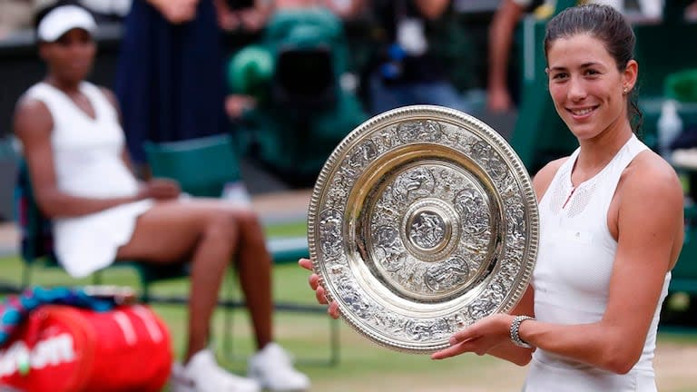 La alegría de Muguruza con su premio mayor; de fondo, Venus Williams